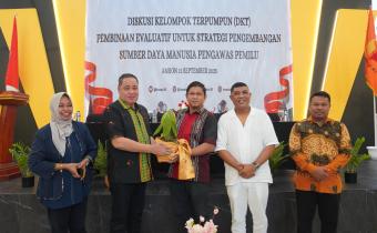 Anggota Bawaslu Herwyn JH Malonda menyerahkan secara simbolis di kegiatan Diskusi Kelompok Terpumpun (DKT) Pembinaan Evaluasi Strategi Pengembangan SDM Pengawas Pemilu yang digelar di Kota Ambon, Jumat (12/9/2025).